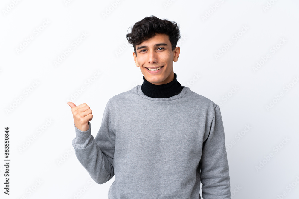 Young Argentinian man over isolated white background pointing to the side to present a product Young Argentinian man over isolated white background pointing to the side to present a product