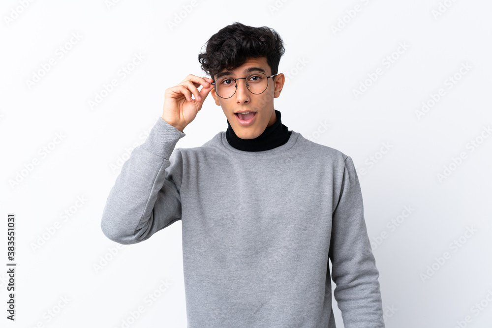 Young Argentinian man over isolated white background with glasses and surprised Young Argentinian man over isolated white background with glasses and surprised