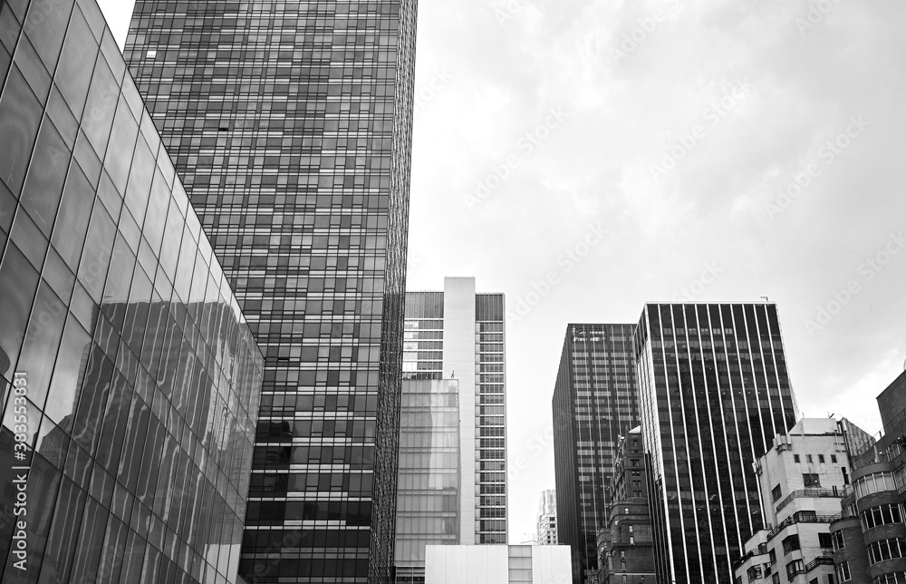 Black and white picture of New York City modern architecture on a cloudy day, USA.