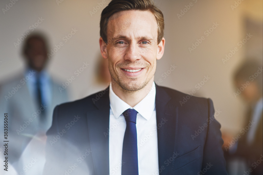 Businessman standing with colleagues in an office Businessman standing with colleagues in an office