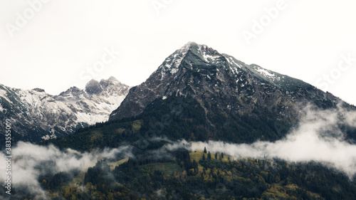 Berge im Nebel mit Schnee vor weißem Hintergrund