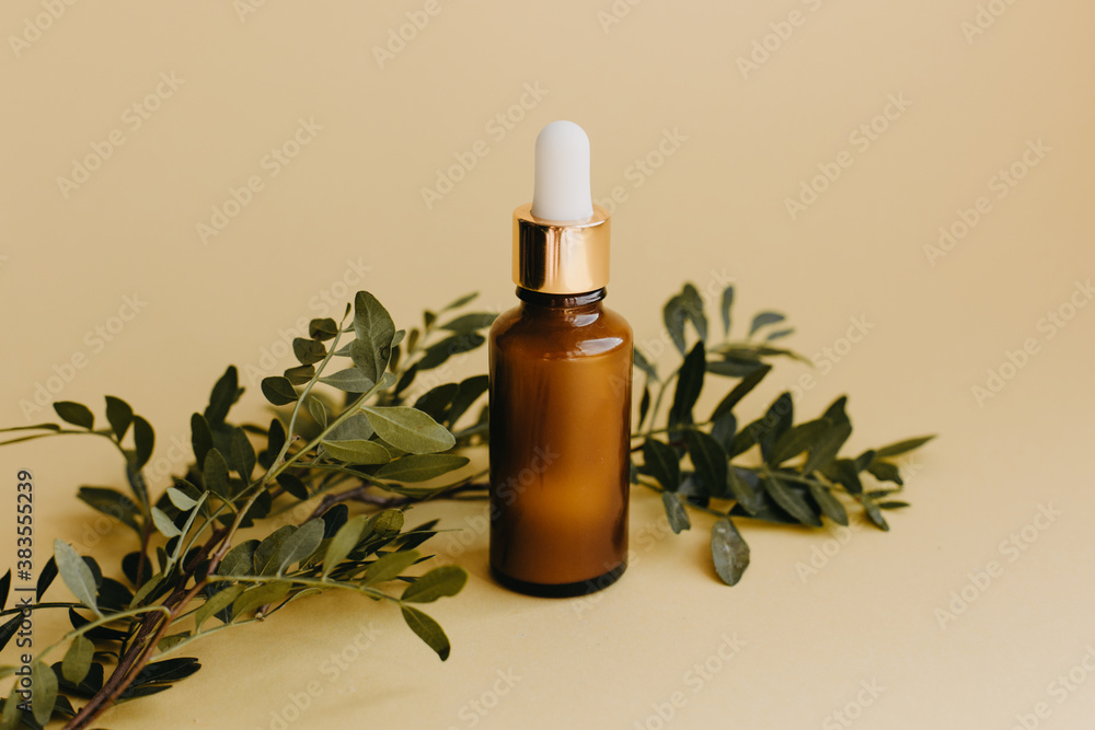 Cosmetic bottle container on yellow background with leaves. Cosmetic bottle container on yellow background with leaves.