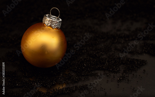 Golden Christmas bauble on black background
