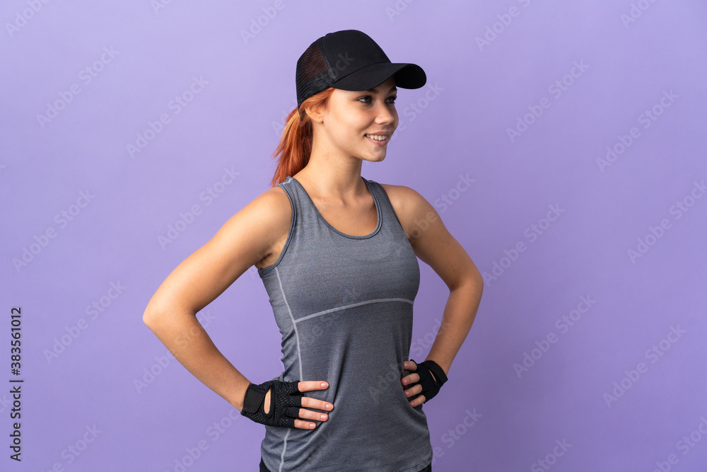 Teenager Russian girl isolated on purple background posing with arms at hip and looking side Teenager Russian girl isolated on purple background posing with arms at hip and looking side