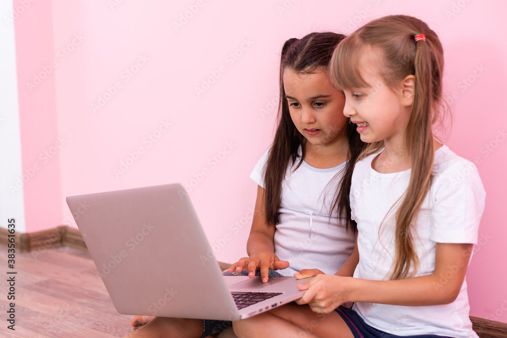 Amazed little kids girls showing white t-shirt, isolated on pink background. Childhood lifestyle concept. Mock up copy space. Pointing index finger aside Amazed little kids girls showing white t-shirt, isolated on pink background. Childhood lifestyle concept. Mock up copy space. Pointing index finger aside