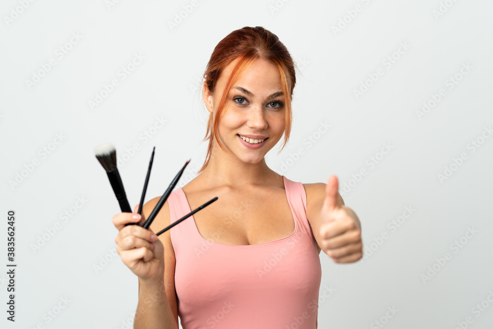 Teenager Russian girl isolated on white background holding makeup brush and with thumb up Teenager Russian girl isolated on white background holding makeup brush and with thumb up
