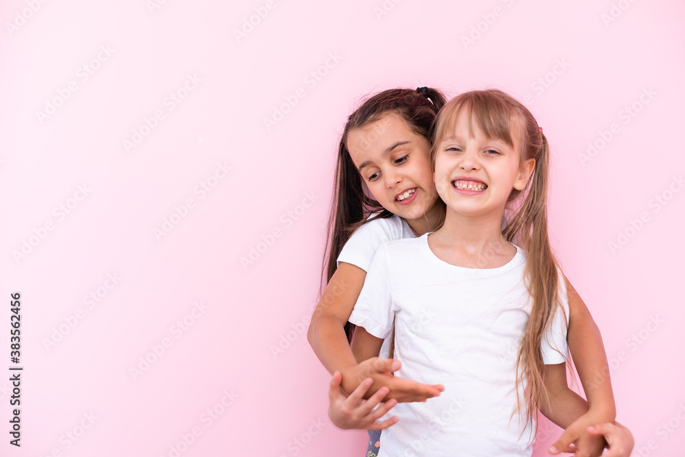 Two little girls - best friends, isolated over on a pink background Two little girls - best friends, isolated over on a pink background