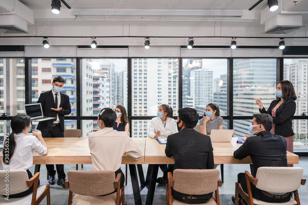 Caucasian businessman presentation of business plan on laptop at conference table, Group of business people wearing face mask meeting in modern office