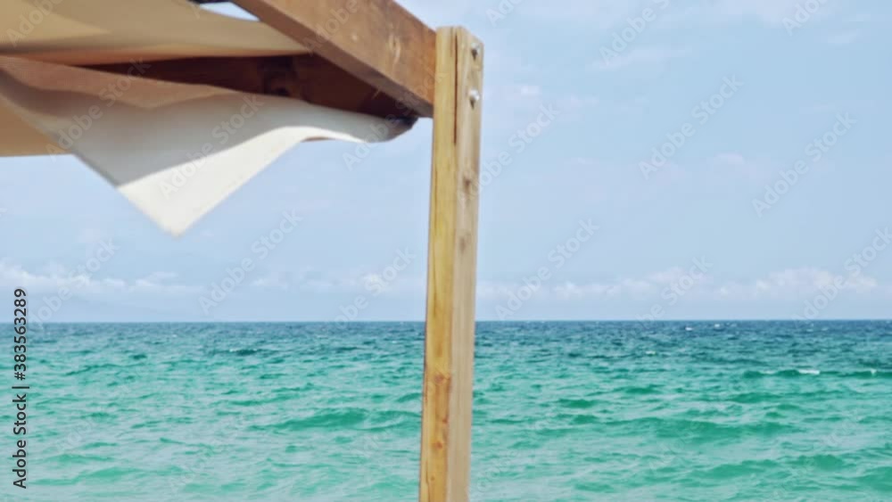 Part of Cabana Sunbed, with beautiful green sea on the background, shallow depth of field, slow motion Part of Cabana Sunbed, with beautiful green sea on the background, shallow depth of field, slow motion