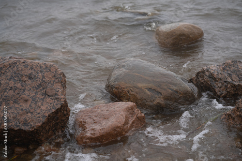 Rocks on the shore washed by dark water