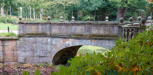 Alte Steinbrücke von 1704. Die Steinbalustrade ist wunderschön gemacht. Das Wasser darunter ist vollständig mit Wasserlinsen bedeckt. Ort: Kloster Frenswegen in Nordhorn, Deutschland photo