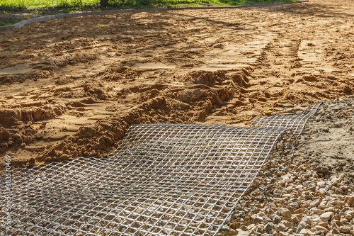 Preparing the foundation of a road in a park using a synthetic geogrid. photo