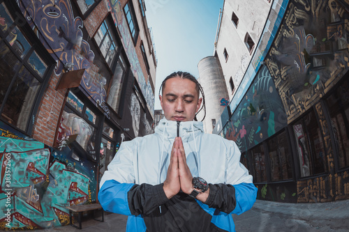 Fototapeta Mexican Latin young man, urban portrait meditating pose