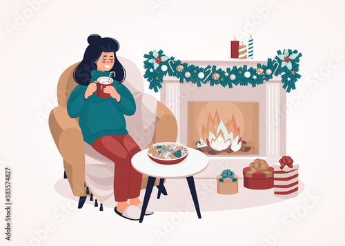 Woman sitting on a chair with a cup by the fireplace and gift boxes