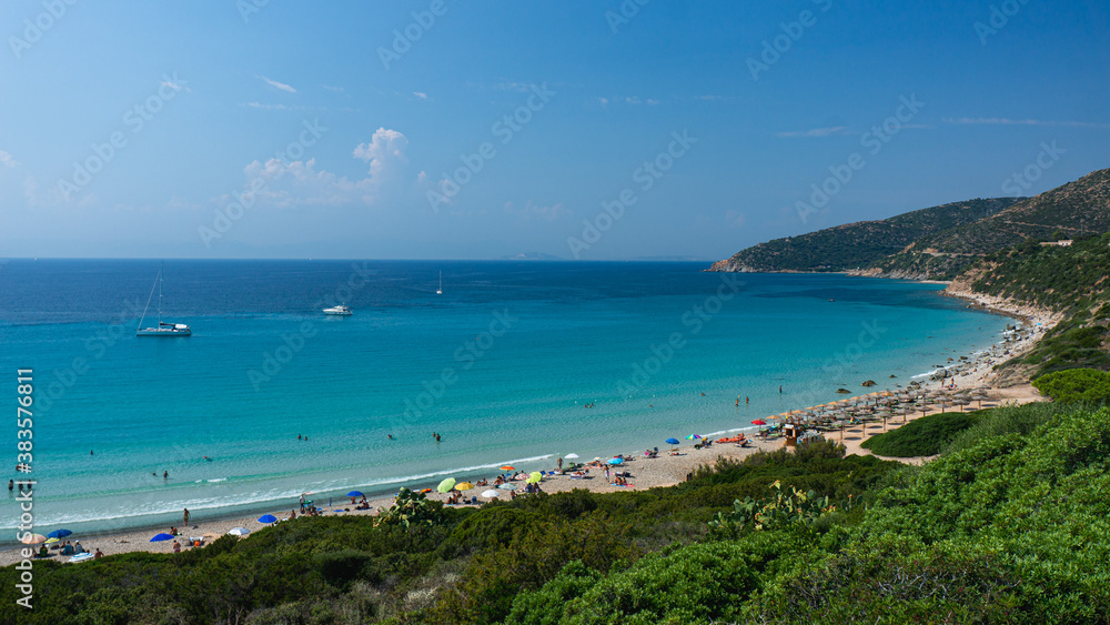 Crowded mediterranean summer beach in Sardinia, Italy. Spiaggia di Mari Pintau.