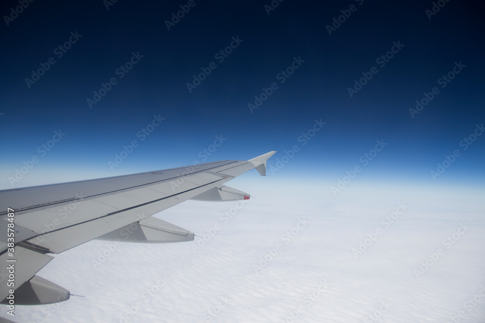 Fototapeta premium airplane wing against the background of clouds and sky