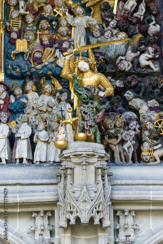Michael the Archangel with a raised sword in front of the Main entrance of the cathedral in Bern, Switzerland