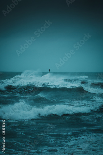 Wild North sea storm at a harbor with heavy storm waves on a dark rainy weather day in Denmark
