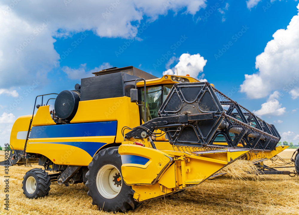 Special machine harvesting crop in fields, Agricultural technic in action. Ripe harvest concept. Crop panorama. Cereal or wheat gathering. Heavy machinery, blue sky above field. Special machine harvesting crop in fields, Agricultural technic in action. Ripe harvest concept. Crop panorama. Cereal or wheat gathering. Heavy machinery, blue sky above field.
