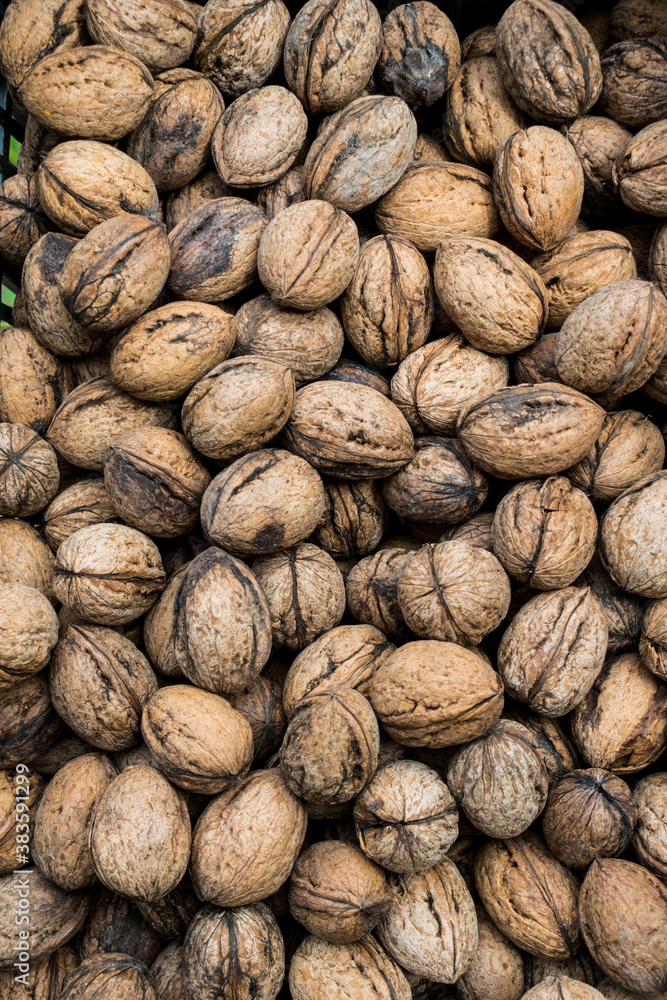 Top view of unshelled browned walnuts on the counter in Greek market. Natural food background of nuts. Top view of unshelled browned walnuts on the counter in Greek market. Natural food background of nuts.