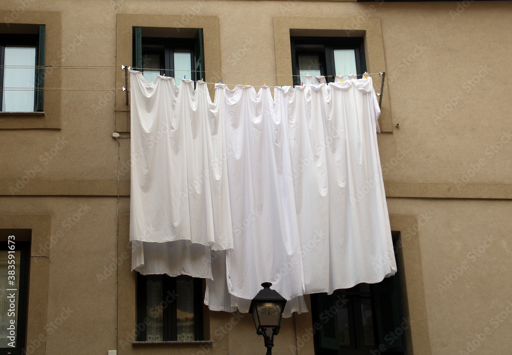 Sábanas blancas tendidas en las ventanas Stock Photo