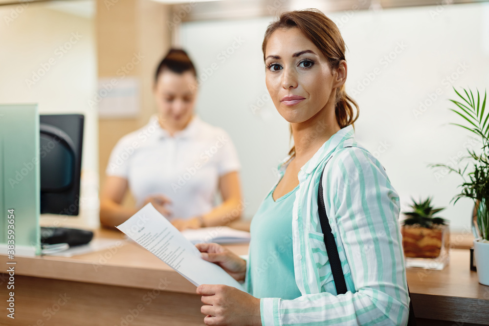Young woman checking in at health spa and looking at camera. Young woman checking in at health spa and looking at camera.