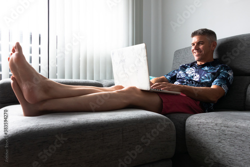 A man on a couch on a conference call with a laptop. Communication