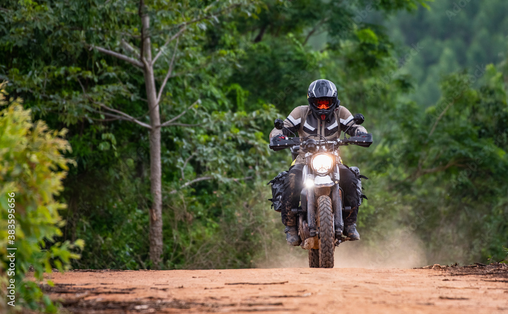 Man riding his motorbike on gravel road in Pak Chong / Thailand Man riding his motorbike on gravel road in Pak Chong / Thailand
