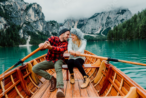 Titolo: Romantic couple on a boat visiting an alpine lake at Braies Italy. Tourist in love spending loving moments together at autumn mountains. Concept about travel, couple and wanderust.

 photo