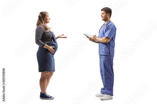 Full length profile shot of a pregnant woman talking to a male doctor