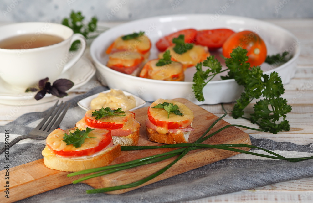 Natural healthy food. Sandwiches on a wooden background for tea. Hot homemade sandwiches with sausage, tomatoes and cheese. Natural healthy food. Sandwiches on a wooden background for tea. Hot homemade sandwiches with sausage, tomatoes and cheese.