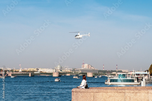 White helicopter of the city administration over the Neva river in St. Petersburg