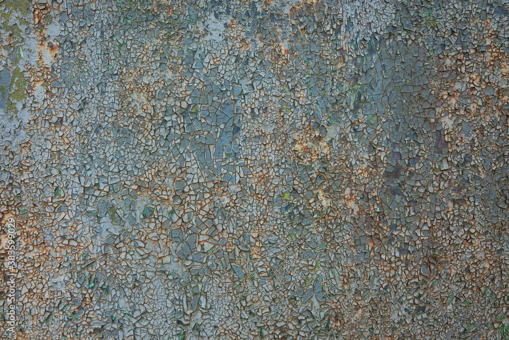 Old sheet metal with cracked gray and blue paint. Rust is visible in the cracks. The texture is like a mosaic. Background. Old sheet metal with cracked gray and blue paint. Rust is visible in the cracks. The texture is like a mosaic. Background.