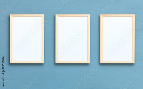 three empty rectangular frames on a blue wall.