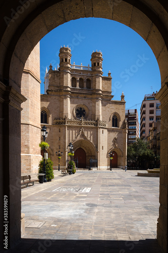 Main square of Castellon de la Plana through an arch with the Co-Cathedral of Santa Maria in the background on a sunny day with a blue sky, Spain photo