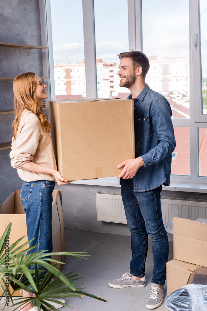 joyful man and woman holding carton box, moving concept joyful man and woman holding carton box, moving concept