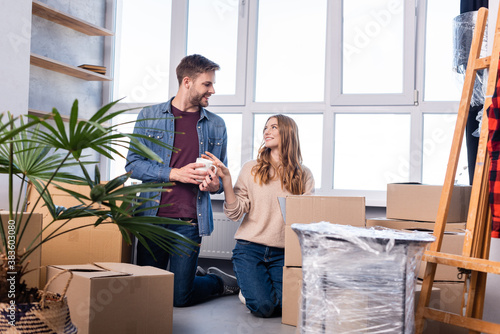 man and woman looking at each other while unpacking carton boxes in new home