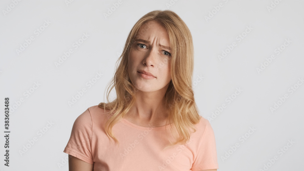 Doubtful girl thoughtfully looking in camera isolated on white b Doubtful girl thoughtfully looking in camera isolated on white b