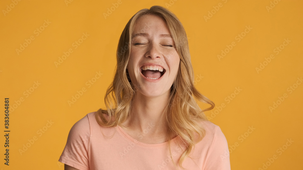 Pretty cheerful girl laughing at something funny over colorful b Pretty cheerful girl laughing at something funny over colorful b