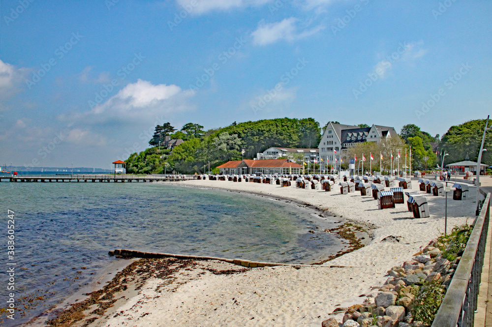 Beach scene with typical hooded windbreak chairs on a quiet beach in Schleswig-Holstein in Germany