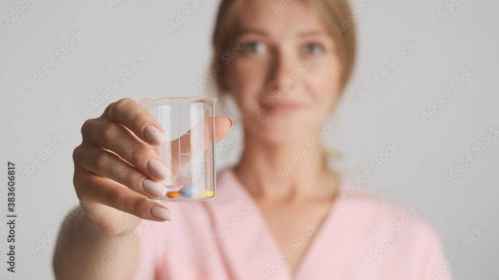 Close up doctor offering medical pills on camera over white back Close up doctor offering medical pills on camera over white back