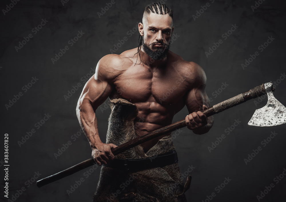 Brutal bodybuilder in fashion of ancient furios viking posing with naked torso and dreadlock in dark dirty background. Brutal bodybuilder in fashion of ancient furios viking posing with naked torso and dreadlock in dark dirty background.