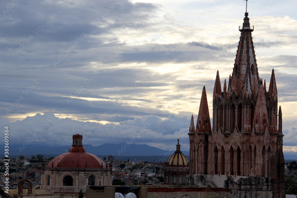 view of dome, cathedral towers and town of San Miguel de Allende at sunset and night in Guanajuato Mexico