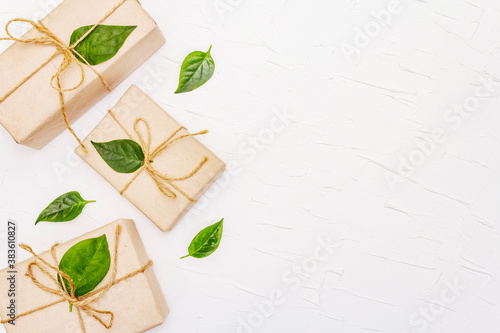 Zero waste gift concept with craft boxes and green leaves