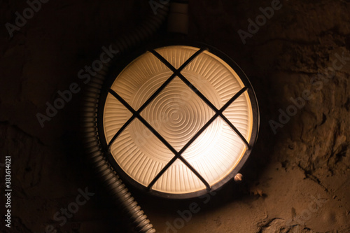 Industrial round light mounted on concrete wall © evannovostro