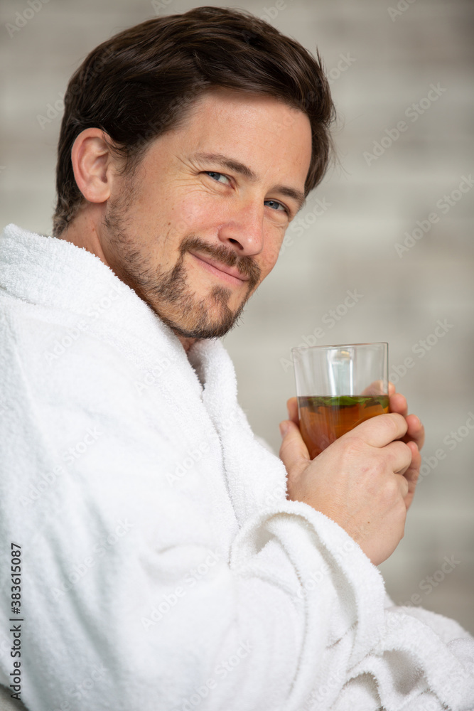 handsome man drinking tea and relaxing in bathrobe handsome man drinking tea and relaxing in bathrobe