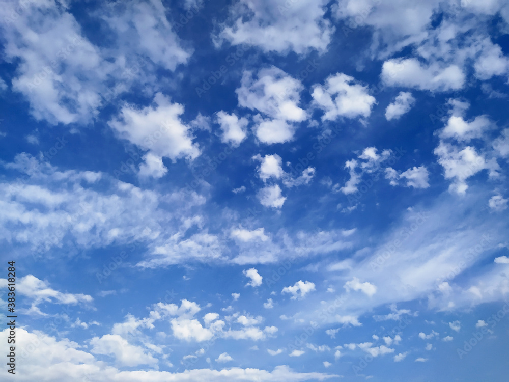Beautiful blue sky with small white cumulus and large cirrus clouds as natural background Beautiful blue sky with small white cumulus and large cirrus clouds as natural background