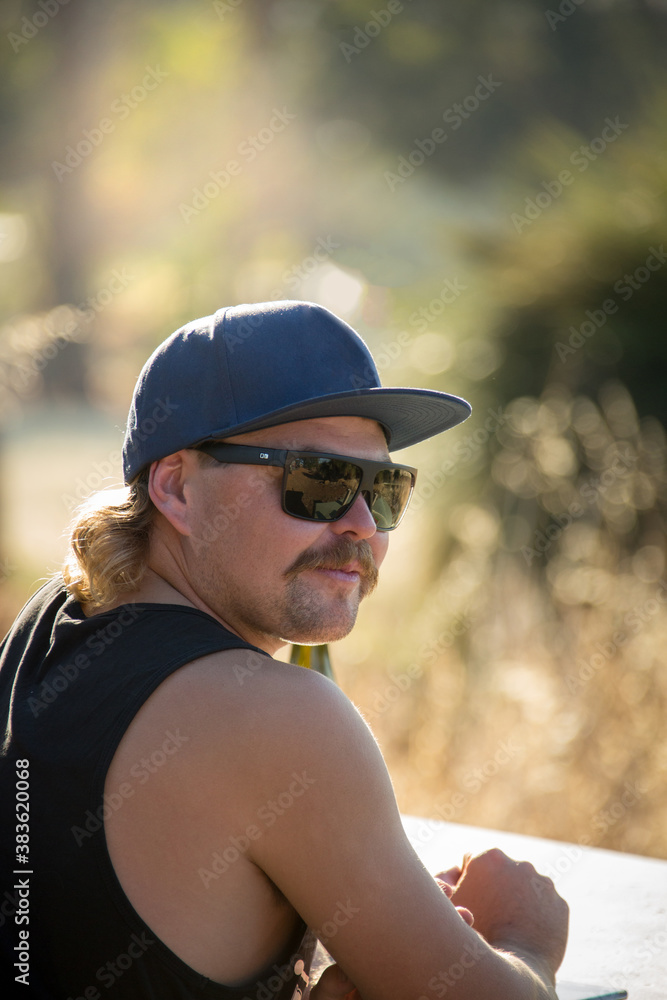 Relaxed young man wearing cap and sunnies Relaxed young man wearing cap and sunnies