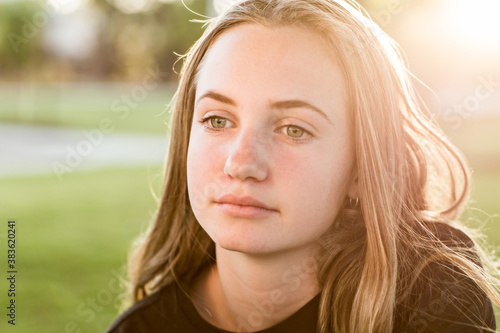 Teenage girl looking wistful,with sun flare photo