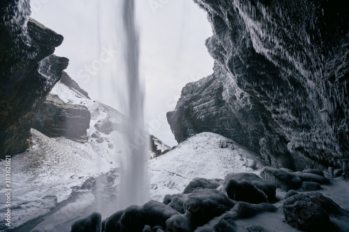 Behind Kvernufoss waterfall in winter, South Iceland. photo